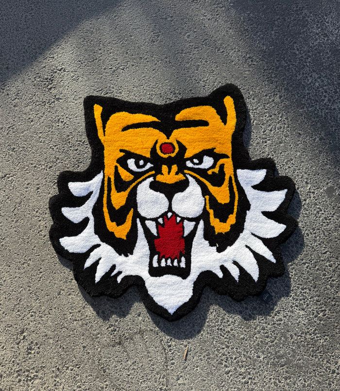 Masked Tiger tufted rug: hand-tufted tiger head rug in amber, black and white with a red gem, made in Amman, Jordan